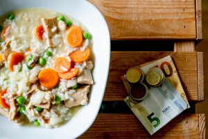 Eine Schüssel Gemüsesuppe mit Karotten und Erbsen auf einem Holztisch. © RUB/Marquard